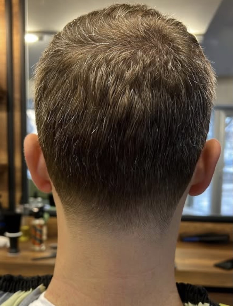 Hoher Skin-Fade mit nach hinten gestyltem Deckhaar